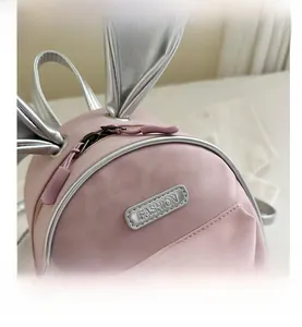 Detailed close-up of pink toddler backpack with silver bunny ears and fashion label