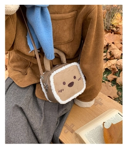 Close-up of cute cat face embroidery on brown plush shoulder bag with fleece trim
