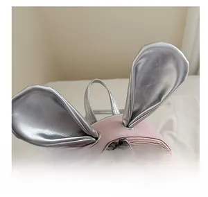 Detail of pink backpack featuring cute silver rabbit ears and polished zipper closure