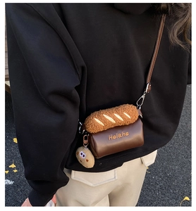Outdoor shot of a child wearing a baguette-shaped plush bag with a cookie charm