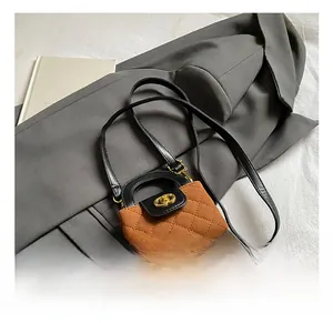 Détail du sac à bandoulière matelassé avec fermoir rotatif en métal doré et poignée