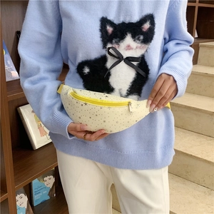 Marsupio bimbo in tela beige con stelle marroni e cerniera gialla indossato da un modello