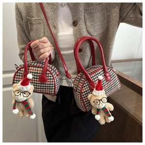 Detail of red houndstooth kids shell bag with cute plush bear charm for autumn and winter