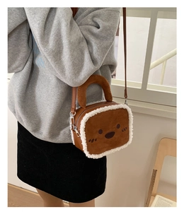 Detail of cute plush shoulder bag with cat face design and faux shearling trim