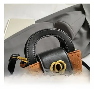 Détail du mini sac à main matelassé avec boucle à double anneau doré et poignée