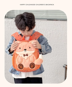 Detail view of cute orange fox backpack for kids with soft plush patches and mesh pocket