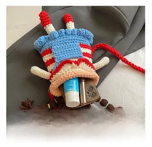 Detail showing internal capacity of handmade crochet crossbody bag with phone and lipstick