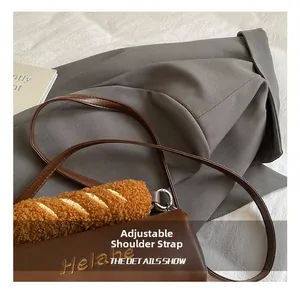 Detail of adjustable leather strap and creative plush baguette decor on brown crossbody bag