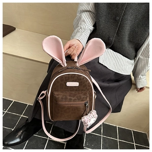 Detail of cute leopard print backpack with rabbit ears and a pink plush charm