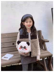 Detail einer süßen Plüsch-Panda-Schultertasche mit roter Wangenstickerei am Kindermodell