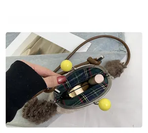 Espace intérieur du sac bandoulière en peluche avec doublure à carreaux et rangement
