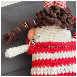 Close-up of handmade crochet ugly-cute doll shoulder bag with striped hair and lobster clasp