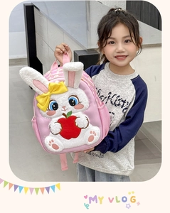 Pink kids backpack featuring a plush 3D bunny holding an apple with side mesh pocket