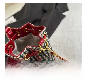 Détail du sac seau à carreaux multicolores avec ferrures dorées et finitions rouges