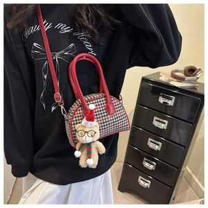 Detail of kids shell bag with houndstooth pattern and cute plush bear accessory