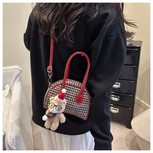 Detailed view of kids plaid shell bag with cute teddy bear plush charm and red handles