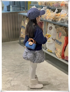 Détail du mini sac matelassé en denim bleu pour enfants avec fermoir doré et poignée