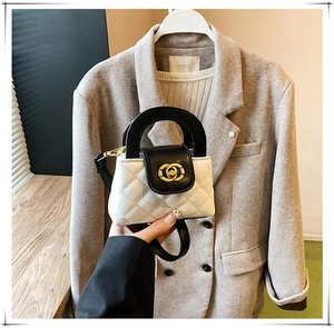 Détail d'un mini sac à main matelassé avec fermoir doré et poignée pour enfants