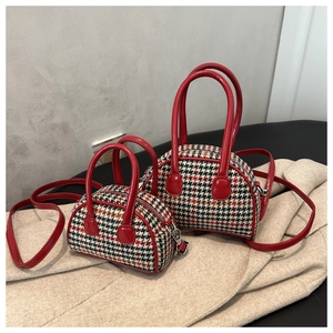 Detailed close-up of plaid kids bowling bags in two sizes with red leather trim and straps