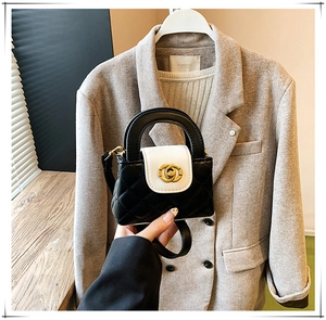 Détail d'un mini sac matelassé bicolore avec un fermoir doré entrelacé élégant