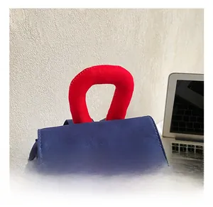 Detail of red padded handle on blue canvas student backpack with sturdy stitching