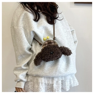 Détail d'un sac bandoulière en peluche de chiot marron avec fermoir rétro et logo fashion