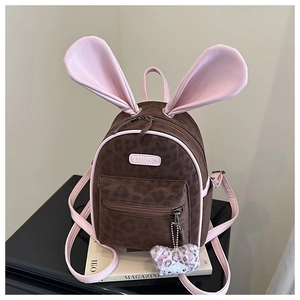 Detail of cute rabbit ears and leopard print on a pink and brown mini backpack