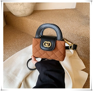 Détail du mini sac matelassé en daim marron avec boucle métallique dorée circulaire