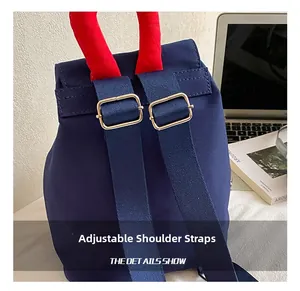 Close-up of adjustable straps with metal buckles on navy blue canvas backpack