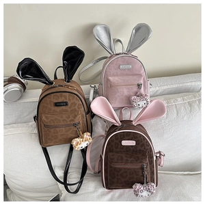 Detail view of leopard print backpack with bunny ears and fluffy cat pendant charm