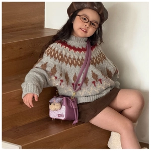 Dettaglio di una borsa a tracolla viola in peluche a forma di cane su un outfit autunnale