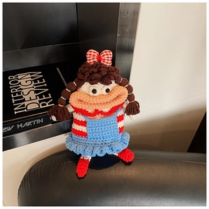 Macro shot of handmade crochet doll bag showing detailed knit texture and woven patterns