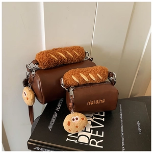 Detail of plush baguette handles and cookie charms on brown leather child handbags