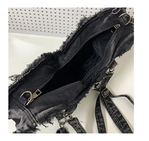 Detail view of large capacity black denim kids bag with raw edges and metal zipper