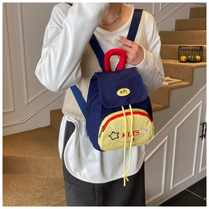 Toddler backpack detail showing color-blocking canvas with star embroidery and KLTS brand tag