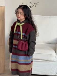 Dettaglio di un abito in maglia a righe per bambine con tessuto operato e mini borsa a tracolla
