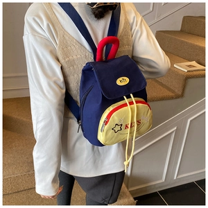 Detail view of mini canvas backpack with blue, yellow and red color block and star embroidery