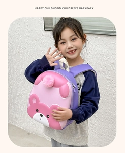 Detail of pink cartoon bear backpack with plush ball and purple straps for toddlers
