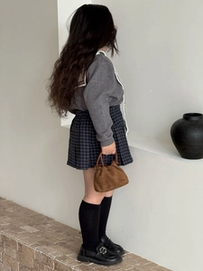 Bambina con borsa a nuvola in camoscio marrone con dettagli plissettati e coulisse