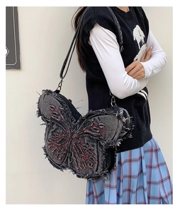 Close-up of butterfly denim bag with red embroidery and frayed edge details