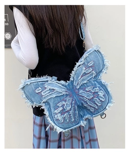 Rear view of child wearing denim butterfly bag with frayed edges and red stitching