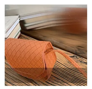 Detail view of orange quilted leather texture and strap attachment on kids crossbody bag