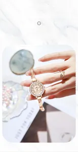 Macro view of rose gold watch featuring a rhinestone bezel and multi-chain tassel strap