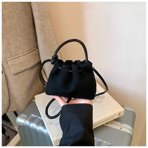 Dettaglio mini borsa a secchiello in camoscio nero con coulisse e manico sottile