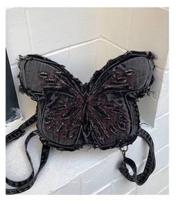 Detailed view of butterfly denim bag with red embroidery and frayed edges on denim