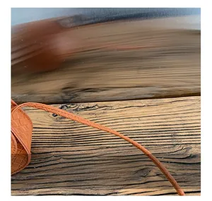 Close-up of brown woven leather shoulder strap showing fine braided texture detail