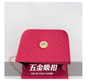 Détail du sac tressé rose avec fermoir magnétique en métal et bandoulière dorée