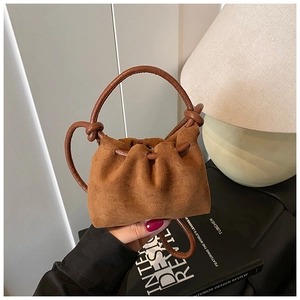 Primo piano della mini borsa a secchiello in camoscio marrone con manico a nodo elegante