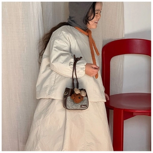 Dettaglio borsa bimbo con trama in tweed e decorazione a forma di orso in maglia