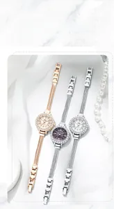 Detailed view of elegant GEDI quartz watches with crystal bezels on marble background